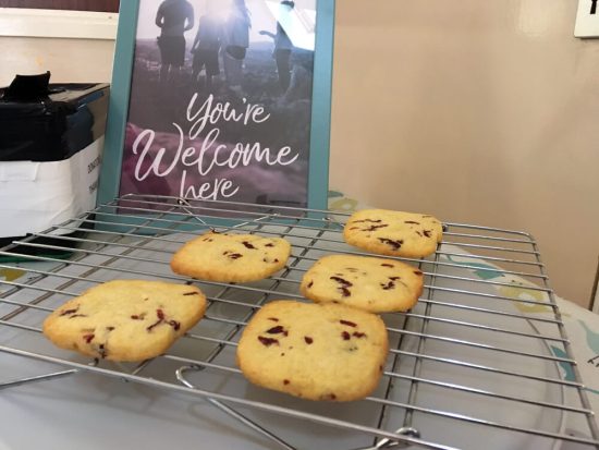 "You're welcome here" sign with freshly baked cookies