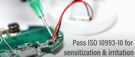 The interior of a wearable device showing adhesive being applied to electronics with the words 